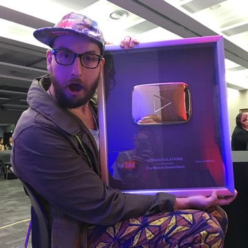 Simon holding the YouTube Gold Play Button